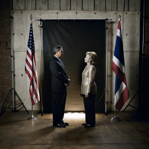 Hillary Clinton and a Thai official in a formal meeting. White background with national flags.