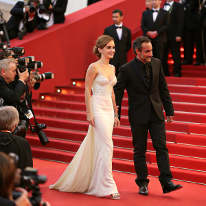 Emma Watson and Alejandro Amenábar at Cannes Film Festival. They are walking the red carpet. Flashing cameras
