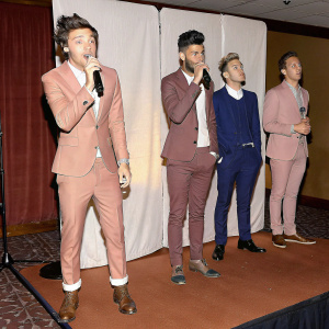 Harry Styles, Zayn Malik, Liam Payne, Louis Tomlinson, and Nick Jonas, standing alone on a white backdrop, performing at the Billboard Music Awards.