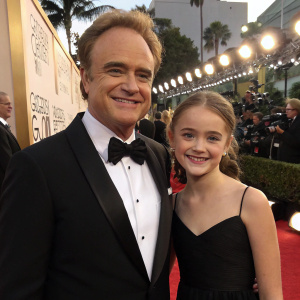 Bradley Whitford and a young girl in formal attire. Golden Globe Awards red carpet event.