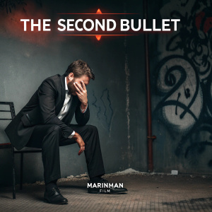 Promotional poster for 'The Second Bullet'. A man in a black suit sitting on a chair, distraught expression. Graffiti-covered wall in dark background. Title 'The Second Bullet' and logo of Marinman Film prominently displayed. Moody and intense atmosphere.