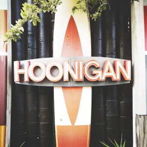 Modern graphic design featuring the Hoonigan logo. Bold, creative font against a black backdrop with vibrant colors.
