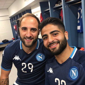 Gonzalo Higuain and Lorenzo Insigne, soccer players from SSC Napoli, posing in the locker room. Higuain in number 9 jersey, Insigne in number 24 jersey, both in navy blue with white details. Close-up, candid shot