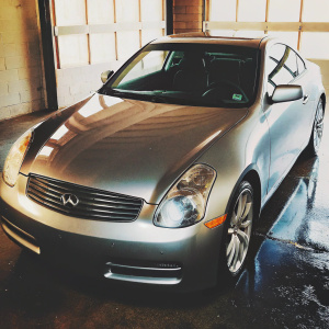 A sleek silver Infiniti G35 Coupe parked in a spacious garage with a white background.