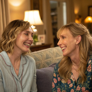 ImageRelation:happy_face ImAltText:ImogenPootsAndToniCollettePosingWithSmiles ImDescription:Imogen Poots and Toni Collette smiling at each other in a cozy living room setting.