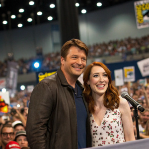 Nathan Fillion and Felicia Day attending a Comic-Con panel. Crowd of fans in the background