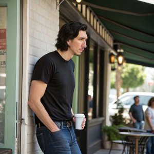 Adam Driver, in a casual black t-shirt and jeans, outside a coffee shop. No backdrop, candid photo.