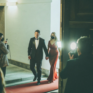 Luis Suarez and Sofia Balbi at the gala. Luis in tuxedo, Sofia in elegant red gown. Red carpet scene with flashing cameras.