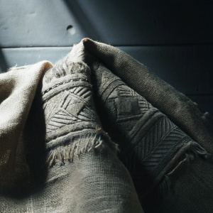 High-resolution close-up of a burlap texture. Rich brown hues with intricate woven patterns