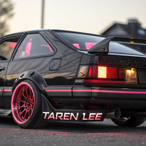 A custom Toyota AE86 Trueno, black exterior with vibrant pinkish-red accents. Detailed lighting design visible from rear angle. Taren Lee nameplate below