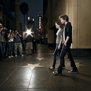 Kristen Stewart and Robert Pattinson, celebrities walking on Hollywood Boulevard. Flashing lights of paparazzi