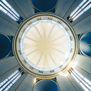 Panoramic shot of the Grand Hall inside Hallgrimskirkja Church. Warm lighting from high windows. Light colors and clean lines create a spacious feel. Floor to ceiling view emphasizing towering structure.