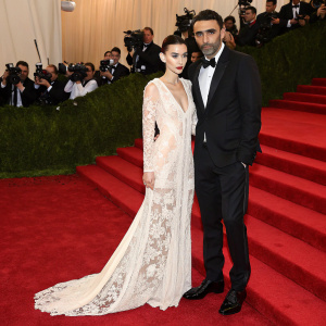 Rooney Mara and Riccardo Tisci at the Met Gala. She wears a flowing white gown with intricate lacework. He is in a tailored black tuxedo.