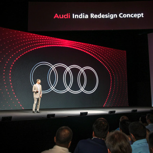 High-tech slideshow. Audi's reimagined identity for Indian market. Dark screen. Interlocking rings and bold red 'Audi' logo. 'Audi India Redesign Concept' header