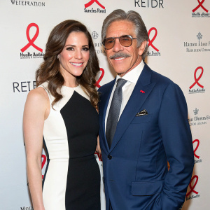 Erica Michelle Levy and Geraldo Rivera at a fundraising event. Both are dressed in formal attire. Erica wears black and white dress. Geraldo in blue suit. Red ribbon AIDS logo backdrop.