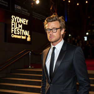 Simon Baker at the Sydney Film Festival. The actor in a sleek black suit and tie, looking serious.