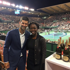 Novak Djokovic and Rama Yade at the sports gala. Crowded venue with spectators. DJ playing music, champagne bottles on table