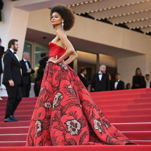 Zendaya at the Cannes Film Festival premiere. Wearing an intricate red carpet gown with a bold floral pattern. Confident pose