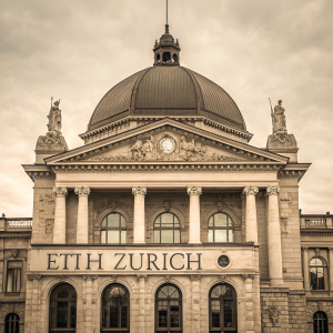 Vintage photo of the ETH Zurich main building. Neoclassical architecture with large dome and detailed stone columns. ETH Zurich emblem visible. Front facade prominently displayed in sepia tone.