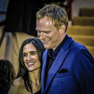 Jennifer Connelly and Paul Bettany, smiling warmly. Jennifer in black evening gown, Paul in navy suit. Close-up photo at awards show.