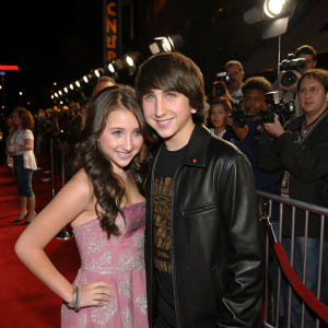 Ryan Newman and Mitchel Musso at a movie premiere. Surrounded by fans and paparazzi, the young girl looks excited.