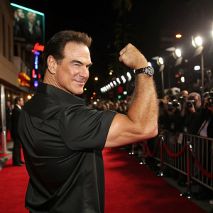 Patrick Warburton, flexing his muscles, in a sleek black shirt. Posing confidently at a Hollywood premiere. Red carpet scene
