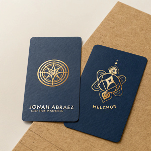 Business cards for Jonah Abraez, CEO of Tech Innovations, and Melchior, a mystical symbol adorned on both cards. Dark blue and gold colors on brown textured paper. Modern design.