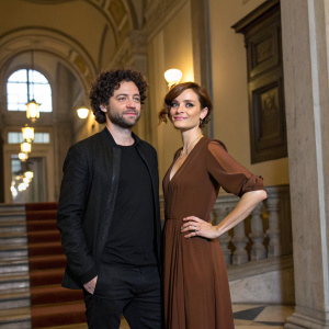 Stefano Lodovichi and Camilla Filippi at the photocall for TV show 'Christian 2'. Cinema Barberini venue. Black t-shirt, curly dark hair, black jacket, long brown gown.