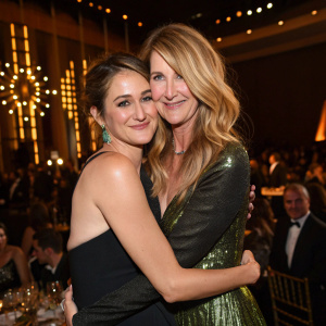 Shailene Woodley and Laura Dern hugging at the Elle Women in Hollywood celebration. The setting is a glamorous event with golden lighting and star-studded guests.
