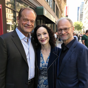 A candid shot of Kelsey Grammer, Bebe Neuwirth, and David Hyde Pierce in modern attire, posing outside on a sunny street during a promotional event.