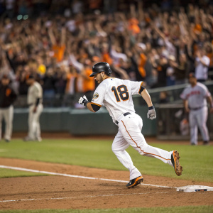 Tyler Collins, baseball player, running towards home base with '18' on his jersey. Crowd cheering in background. Dugout blurred