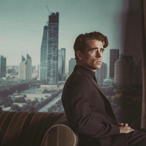 Colin Farrell in a sleek black suit. GQ Magazine cover shoot, modern cityscape backdrop
