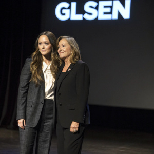 Billie Lourd and Ava Bozzi attending a GLSEN event. They stand together on a dimly lit stage with the GLSEN logo as the only visual element behind them.