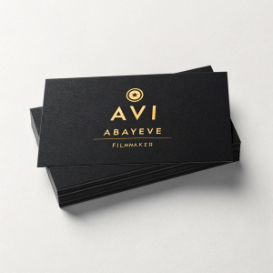 A sleek business card design for Avi Abayeve Filmmaker. Glossy black cardstock, logo in gold, minimalist layout, modern font.