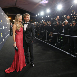 Nico Rosberg and Vivian Sibold at a glamorous awards ceremony. Black carpet, numerous photographers, bright spotlights