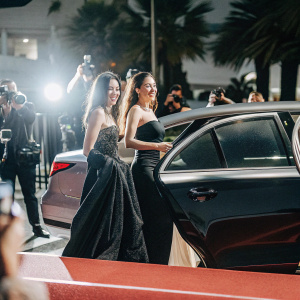 Elizabeth Jagger and Georgia May Ayeesha at Cannes Film Festival. They are elegantly dressed. Crowded street scene with flashing cameras.