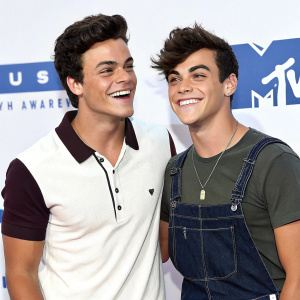 Ethan Dolan and Grayson Dolan, two young men, at the VMAs. Casual outfits, standing close, against white backdrop. Bright and cheerful vibe