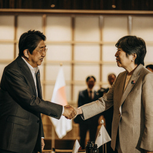 A formal handshake between Song Min-soon, South Korean minister, and Shinzo Abe, Japanese PM, during a diplomatic summit.