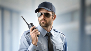 Cool security guard without glasses talking on a walkie-talkiee
