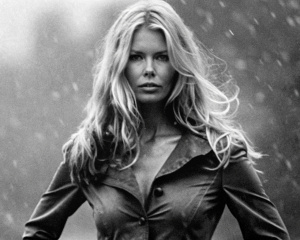 absolutely braless under the clothes 76 years old aged Claudia Schiffer holding her hips, full height body under the Amsterdam rain. B/w photoshot on Sony Alpha. Bokeh. 