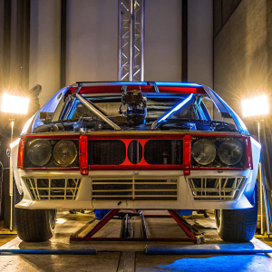 A meticulously detailed Lancia 037, with classic Martini Racing livery. The car gleams under studio lights, showcasing intricate engine components and aerodynamic design elements.
