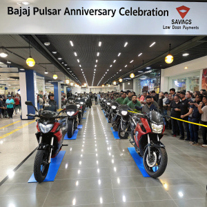 Bajaj Pulsar anniversary celebration. Motorcycles lined up on a showroom floor. Crowd of enthusiasts around. Promotional banners about savings and low down payments