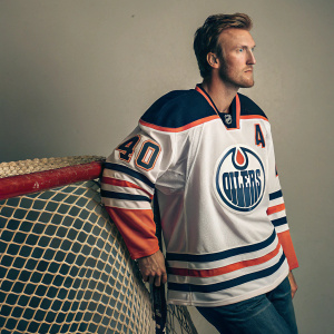 Devan Dubnyk, Edmonton Oilers hockey player, wearing number 40 jersey. Posing in a studio with a hockey net in the background.