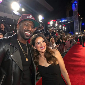 Destorm Power and Janina Gordillo at the premiere of a blockbuster movie. Crowds cheering, flashing lights
