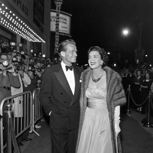 Douglas Fairbanks Jr. and Rosalind Russell attending the premiere of 'The Crooked Hearts'. Crowded red carpet with flashing cameras.