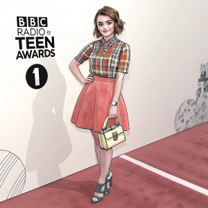 Maisie Williams on the red carpet at the BBC Radio 1 Teen Awards. She is wearing a plaid shirt and a vibrant orange skirt. Holding a small structured handbag and wearing metallic accessories. The background is a plain white wall with logos and text.