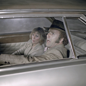 James Caan and Sally Kellerman in 'Slither' (1973). Black and white photo. Inside a car, Sally looks scared, James looks intense. Classic 70s film still.