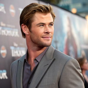 Close-up portrait of Chris Hemsworth. Clean-shaven look. Wearing a tailored grey suit. On set of Thor: Love and Thunder promotional campaign.