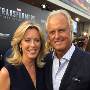 Deborah Norville and Karl Wellner, both blonde, smiling at press conference for 'Transformers: Age of Extinction'.