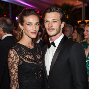 Gaelle Pietri and Gaspard Ulliel at the Cannes Film Festival after-party. Gaelle in an elegant black lace dress, Gaspard in a sharp tuxedo. Crowded and vibrant celebration setting.